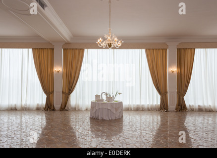 Un tavolo bianco con bomboniera in una grande sala di lusso Foto Stock