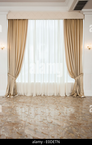 Luxury drappi beige in una grande sala luminosa Foto Stock