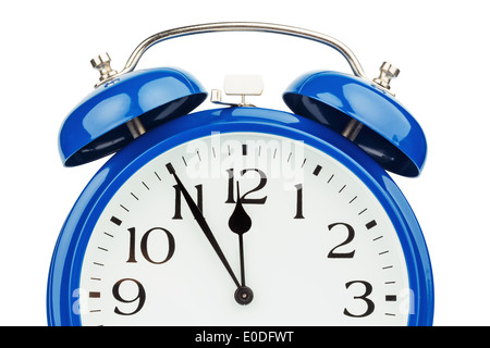 Un blu sveglia su sfondo bianco. Cinque prima di dodici, Ein blauer Wecker auf weissem Hintergrund. Fuenf Zwoelf vor Foto Stock
