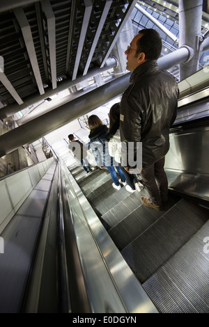 Persone che viaggiano verso il basso su una scala mobile alla stazione di Westminster sulla metropolitana di Londra, in Inghilterra, Regno Unito Foto Stock