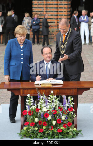 Straslund, Germania. Il 10 maggio, 2014. Il cancelliere tedesco Angela Merkel (1L) attende mentre la visita del Presidente francese Francois Hollande autografi della città guest book nel Mar Baltico città costiera di Stralsund, Germania, il 9 maggio 2014. Il Presidente francese Francois Hollande arrivati venerdì nel Baltico una città costiera nel nord della Germania, dando dei calci a fuori di una visita di due giorni in Germania per colloqui con il Cancelliere tedesco Angela Merkel. Credito: Xinhua/Alamy Live News Foto Stock