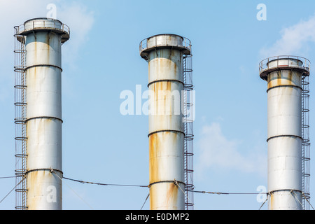 Ciminiere delle centrali a carbone vegetale contro il cielo blu Foto Stock