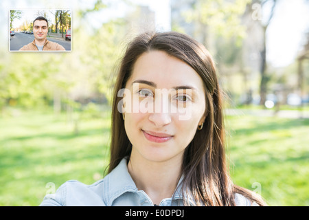 Ragazza giovane e carina video chiamata con il giovane uomo Foto Stock