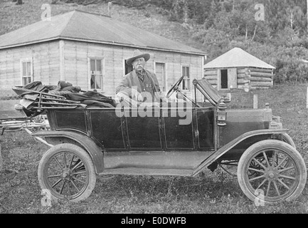 Kootenai Brown appoggiata contro un'automobile di fronte la sua cabina Foto Stock