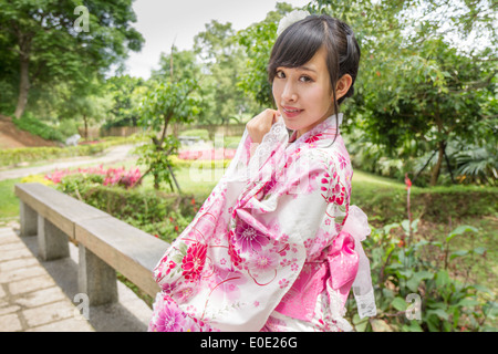 Signora cinese di indossare il kimono in stile Giapponese tradizionale in giardino Foto Stock