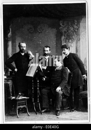 Una fotografia in bianco e nero di un gruppo di uomini riuniti intorno a uno stand musicale, probabilmente da un raduno storico o evento culturale all'inizio del XX secolo. Foto Stock