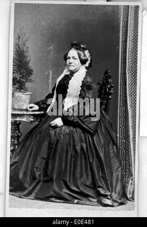 Un ritratto vintage di una donna anziana seduta all'aperto, catturato in una fotografia in bianco e nero dell'inizio del XX secolo. L'immagine riflette la moda e le tendenze sociali di quell'epoca. Foto Stock