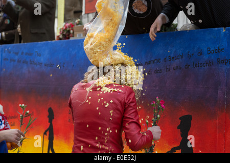 Una fotografia di una ragazza bionda, o donna, essendo coperto di coriandoli a carnevale. Foto Stock