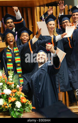 Syracuse, New York, Stati Uniti d'America. Il 10 maggio, 2014. Uno studente dalla Syracuse University School of Architecture celebra la ricezione del suo diploma prendendo un 'selfie' fotografia con i compagni di classe in background durante la cerimonia di inizio per la scuola di architettura presso la Syracuse University in Syracuse, New York. Credito: Nicolaus Czarnecki/ZUMAPRESS.com/Alamy Live News Foto Stock