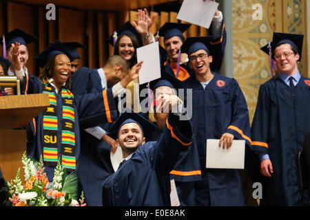 Syracuse, New York, Stati Uniti d'America. Il 10 maggio, 2014. Uno studente dalla Syracuse University School of Architecture celebra la ricezione del suo diploma prendendo un 'selfie' fotografia con i compagni di classe in background durante la cerimonia di inizio per la scuola di architettura presso la Syracuse University in Syracuse, New York. Credito: Nicolaus Czarnecki/ZUMAPRESS.com/Alamy Live News Foto Stock