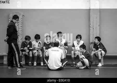 Buenos Aires, Argentina. Il 10 maggio, 2014. Il coach di Penacho Azul, Matias Barcia anteriore (C) parla con i relativi sostituti durante un match contro Club Arquitectura, per la seconda data della Federazione della gioventù nelle scuole calcio (FEFI, per il suo acronimo in spagnolo) torneo, nella città di Buenos Aires, capitale dell'Argentina, il 10 maggio 2014. Sebbene circa 50.000 bambini argentini da 400 club di calcio, prendere parte in allenamento per il calcio e tornei, molto pochi di loro riescono ad avere una carriera come profesional giocatori. Credito: Martin Zabala/Xinhua/Alamy Live News Foto Stock