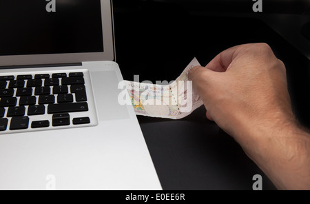 Cyber furto o fare soldi concetto shot con il computer portatile e denaro Foto Stock