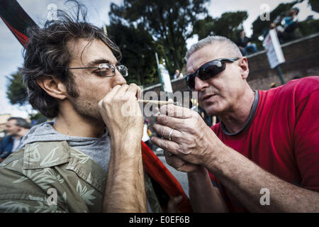Roma, Italia. Il 10 maggio, 2014. Roma, Italia '"" 10 Maggio 2014: un uomo fuma un giunto durante il Global Marijuana marzo a Roma per chiedere la legalizzazione della marijuana Sabato 10 Maggio, 2014. Migliaia di persone hanno marciato nel centro di Roma durante il Global Marijuana marzo, un rally annuale tenuto in diverse ubicazioni in tutto il pianeta, chiedere la legalizzazione della marijuana e cambiamenti nelle politiche in materia di droga. Il Global Marijuana marzo (MGM) va anche con il nome di tutto il Mondo di Marijuana marzo (WMM) o Million Marijuana March (MMM) Credito: Giuseppe Ciccia/NurPhoto/ZUMAPRESS.com/Alamy Live News Foto Stock