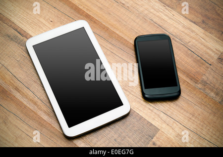 Telefono cellulare e tablet con display vuoto od sfondo di legno Foto Stock