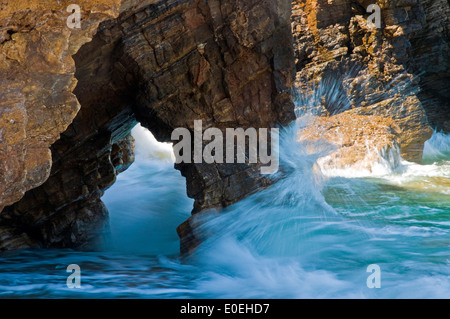 Onde del mare Egeo Schiantati sulla costa rocciosa Foto Stock