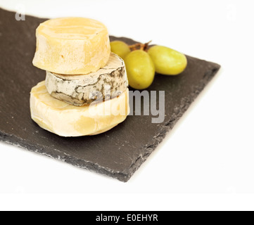 Pila di formaggio camembert e uva sulla lastra di pietra Foto Stock