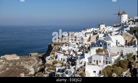 Gli iconici mulini a vento bianchi si affacciano sul Mar Egeo nel pittoresco villaggio di Oia, Santorini Foto Stock