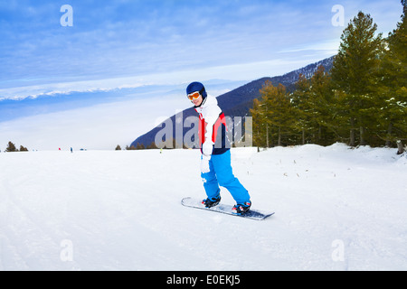 Uomo che indossa la maschera da sci in piedi su snowboard Foto Stock