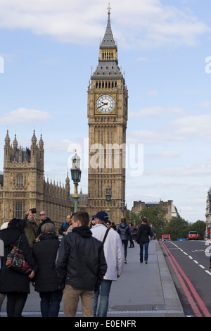 Turisti attraversando Westminster Bridge dirigendosi verso le Case del Parlamento City of Westminster London Inghilterra England Foto Stock