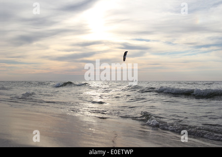 Mare con irriconoscibile silhouette di kitesurfer all'orizzonte Foto Stock