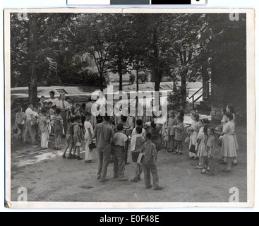 Una fotografia che mostra i bambini allineati nel cortile della JEC Annex, parte di un evento della comunità organizzato dalla Jewish Historical Society of the Upper Midwest. L'immagine evidenzia il ruolo del centro nell'ospitare riunioni sociali per bambini. Foto Stock