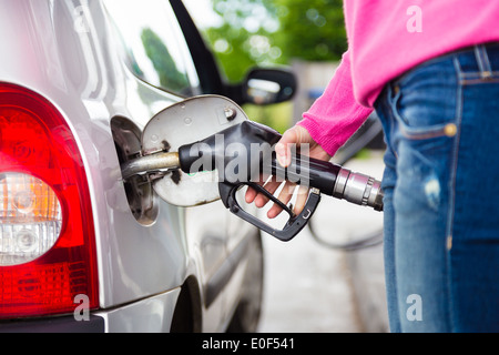 Lady di pompaggio del carburante benzina in auto alla stazione di gas. Foto Stock