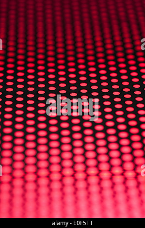 Griglia in metallo con modelli di fori e luci colorate Foto Stock