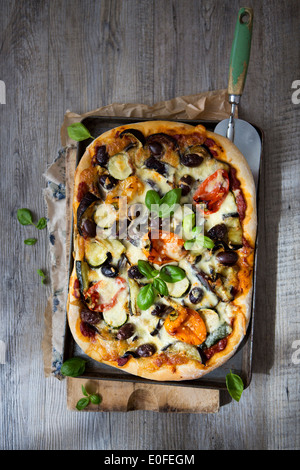 In casa di Verdure arrosto Pizza con olive, basilico e peperoni Foto Stock
