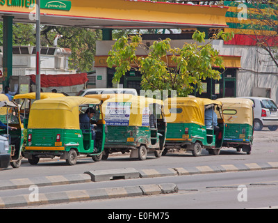 Coda di risciò motorizzati in corrispondenza di una stazione di riempimento a Delhi. Questo tipo di veicolo è ampiamente utilizzato per brevi viaggi nelle città indiane Foto Stock