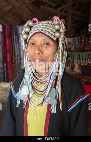 Akha tribeswoman in abbigliamento tradizionale e indossando un copricapo ornati, Chiang Mai, Thailandia Foto Stock