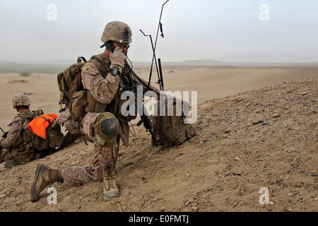 Marines americani Lt. Robert Kay Jr., comandante di plotone con il bravo Company assault force fornisce un report sulla situazione via radio durante un contatore insurrezione missione Maggio 1, 2014 nel villaggio di Tagvreshk, provincia di Helmand, Afghanistan. Foto Stock