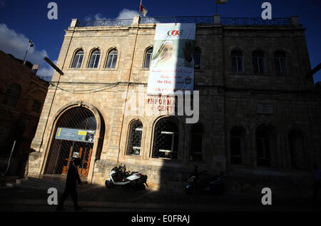 Gerusalemme, Gerusalemme, Territorio palestinese. Il 12 maggio 2014. Un Ultra ebrea ortodossa uomo cammina davanti a una grande poster del Papa Francesco a Christian Information Center nella città vecchia di Gerusalemme, 12 maggio 2014. Più di 200 ebrei ortodossi hanno protestato lunedì contro il papa la prevista visita al sito dove i cristiani credono Gesù Cristo ha avuto la sua Ultima Cena © Saeed Qaq APA/images/ZUMAPRESS.com/Alamy Live News Foto Stock