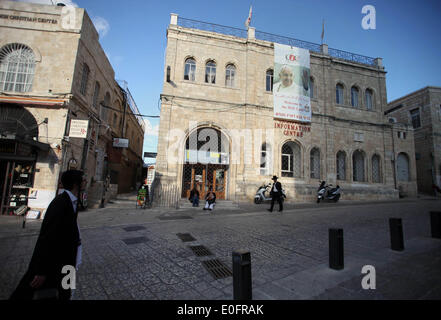 Gerusalemme, Gerusalemme, Territorio palestinese. Il 12 maggio 2014. Ultra ebrei ortodossi a piedi passato un grande poster del Papa Francesco a Christian Information Center nella città vecchia di Gerusalemme, 12 maggio 2014. Più di 200 ebrei ortodossi hanno protestato lunedì contro il papa la prevista visita al sito dove i cristiani credono Gesù Cristo ha avuto la sua Ultima Cena © Saeed Qaq APA/images/ZUMAPRESS.com/Alamy Live News Foto Stock