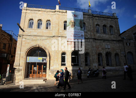 Gerusalemme, Gerusalemme, Territorio palestinese. Il 12 maggio 2014. Gli israeliani a piedi passato un grande poster del Papa Francesco a Christian Information Center nella città vecchia di Gerusalemme, 12 maggio 2014. Più di 200 ebrei ortodossi hanno protestato lunedì contro il papa la prevista visita al sito dove i cristiani credono Gesù Cristo ha avuto la sua Ultima Cena © Saeed Qaq APA/images/ZUMAPRESS.com/Alamy Live News Foto Stock