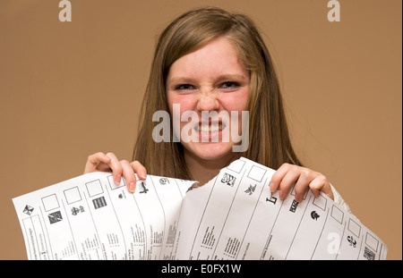 Angry Young lacerazione voto voto cartaceo con imbarazzo la carta di voto Foto Stock