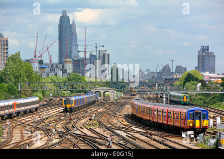 I treni e i binari dei trasporti pubblici di Clapham Junction sono molto trafficati, con la St Georges Tower Vauxhall e i punti di riferimento di Shard sullo skyline di Londra oltre l'Inghilterra UK Foto Stock