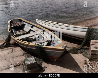 Vecchie barche di legno con reti da pesca su una riva Foto Stock