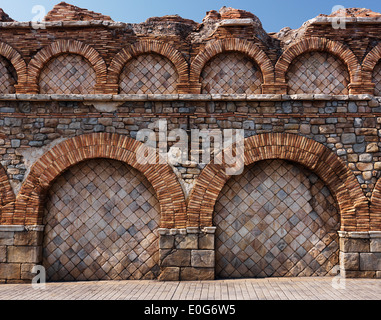 Il vecchio muro di pietra con archi in mattoni antichi di architettura rustica texture Foto Stock