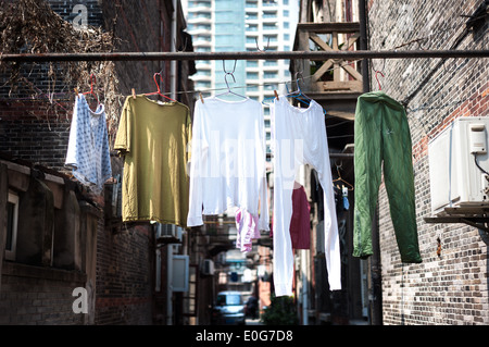 Appendere il lavaggio in un vecchio quartiere di Shanghai Foto Stock