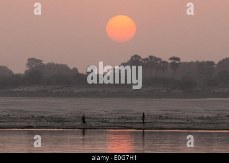 Varanasi (India). 13 Maggio, 2014. Persone giocare in riva al fiume come il sole sorge sopra il fiume Gange a Varanasi, Uttar Pradesh, India, 13 maggio 2014. Credito: Zheng Huansong/Xinhua/Alamy Live News Foto Stock