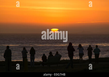 Cambria, California, Stati Uniti d'America. Il 12 maggio 2014. La gente guarda il tramonto da un promontorio sulla costa centrale della California. Credito: Jonathan Alcorn/ZUMAPRESS.com/Alamy Live News Foto Stock