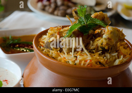 Biryani, un piatto fatto da una lenta cottura del riso profumato con erbe e spezie a fianco, verdure, carni o frutti di mare.  Foto Stock