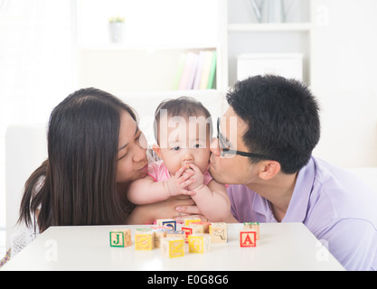 I genitori dando loro la nostra bambina un bacio attacco. Foto Stock