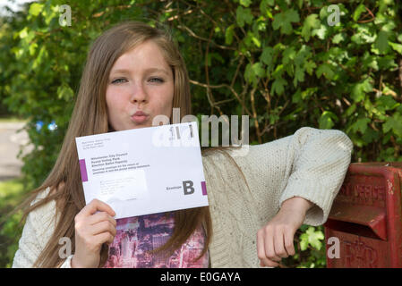 Silchester, Hampshire, Regno Unito. Il 12 maggio 2014. Voto postale per il Maggio elezioni del Parlamento europeo arriva. I giovani elettori parchi Hollie da Hampshire baciare il suo voto postale addio al postbox Credito: Pietro Titmuss/Alamy Live News Foto Stock