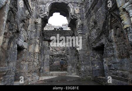 Srinagar, Indiano-controllato del Kashmir. Il 12 maggio 2014. Un uomo cammina dentro le rovine di Martand Tempio del Sole , nel villaggio di Mattan del distretto Anantnag, circa 65 km a sud di Srinagar, la capitale estiva di Indiano-Kashmir controllata, 12 maggio 2014. Martand Sun tempio è uno dei più importanti siti archeologici in indiano-Kashmir controllata. Il tempio è stato costruito intorno al 500 D.C. per essere dedicato a Surya (Sun) Dio ed è ormai in rovina. Credito: Javed Dar/Xinhua/Alamy Live News Foto Stock
