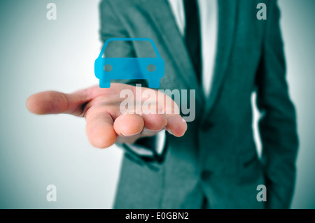 Un imprenditore con un icona di auto in mano Foto Stock