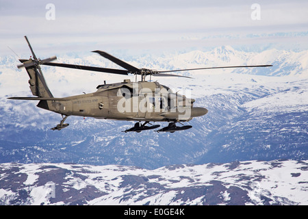 Un esercito americano UH-60 Black Hawk elicottero dotato di cieli di neve e di lungo raggio serbatoi carburante vola sopra il Denali gamma durante l'Arctic Pegasus Aprile 30, 2014 en route a Deadhorse, Alaska. Foto Stock