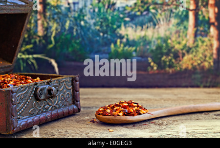 Secchi peperoncino rosso in scaglie su tavola in legno rustico Foto Stock