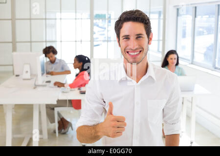 Lavoratore sorridente dando pollice in alto Foto Stock