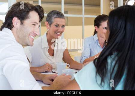 La gente di affari sorriso e chattare mentre godendo bevande calde Foto Stock